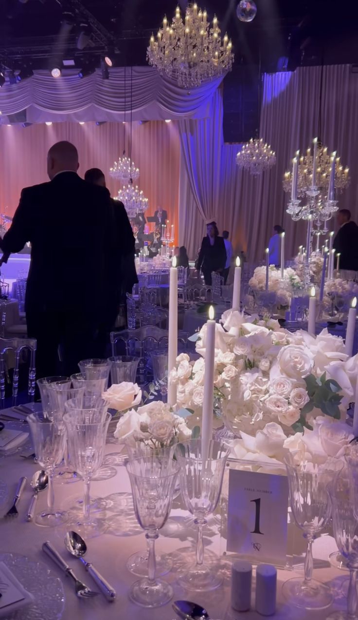 a table is set up with candles and flowers for a formal function at a wedding