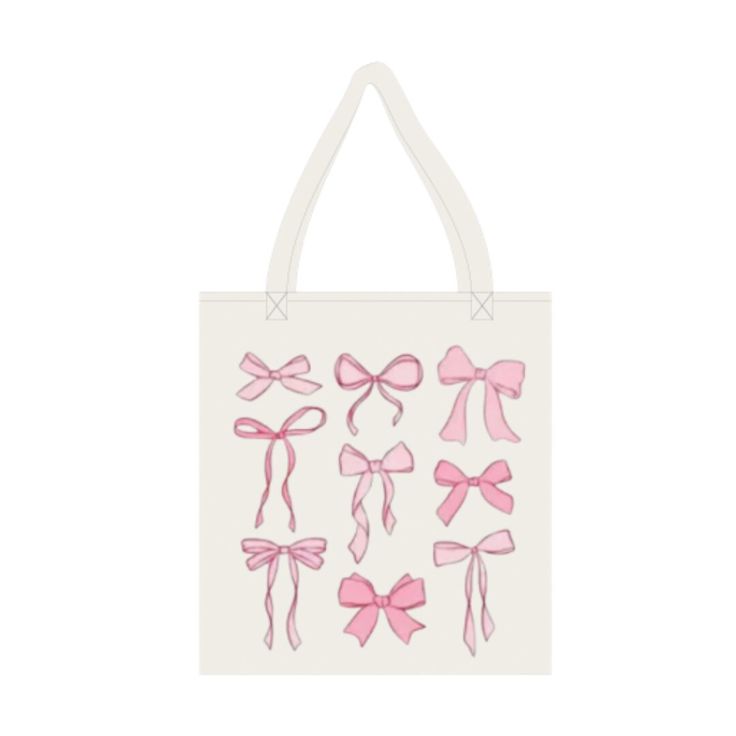 a white bag with pink bows on the front and back of it, hanging from a wall