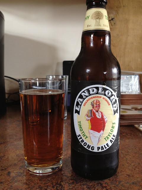 a bottle of beer sitting on top of a table next to a glass filled with liquid