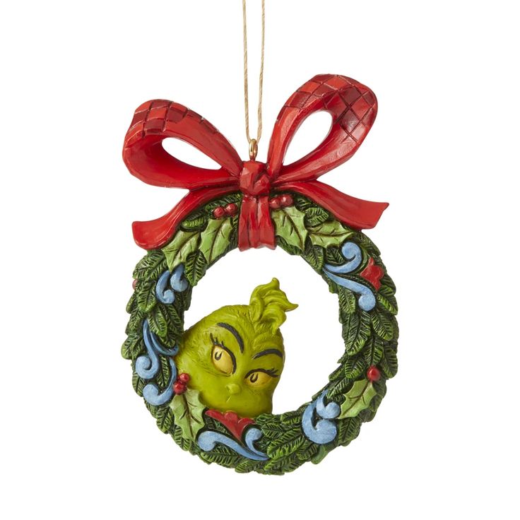 a christmas wreath ornament with a grin face hanging from it's side