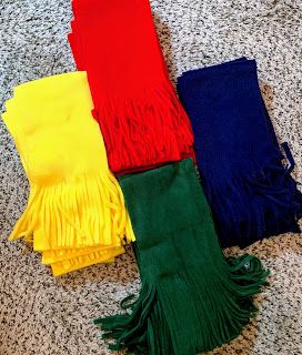 four different colors of scarves laying on the floor next to each other with fringes