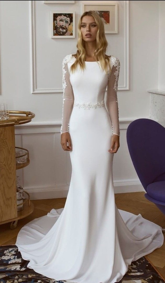 a woman in a white wedding dress standing next to a purple chair and blue chair