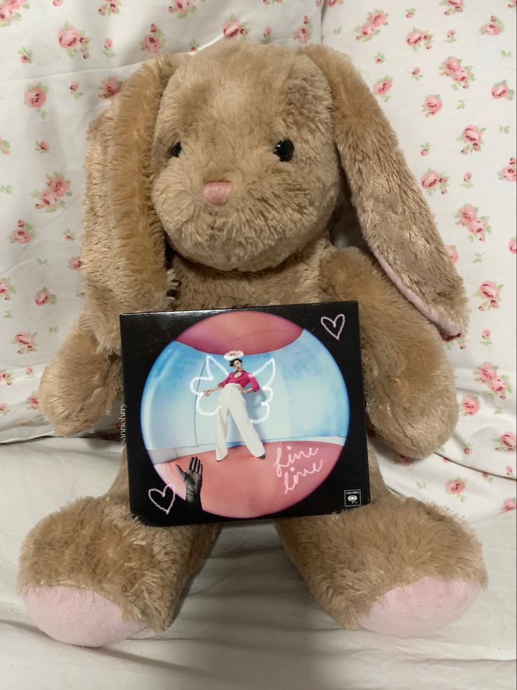 a stuffed rabbit holding a card with the image of a man on it's chest