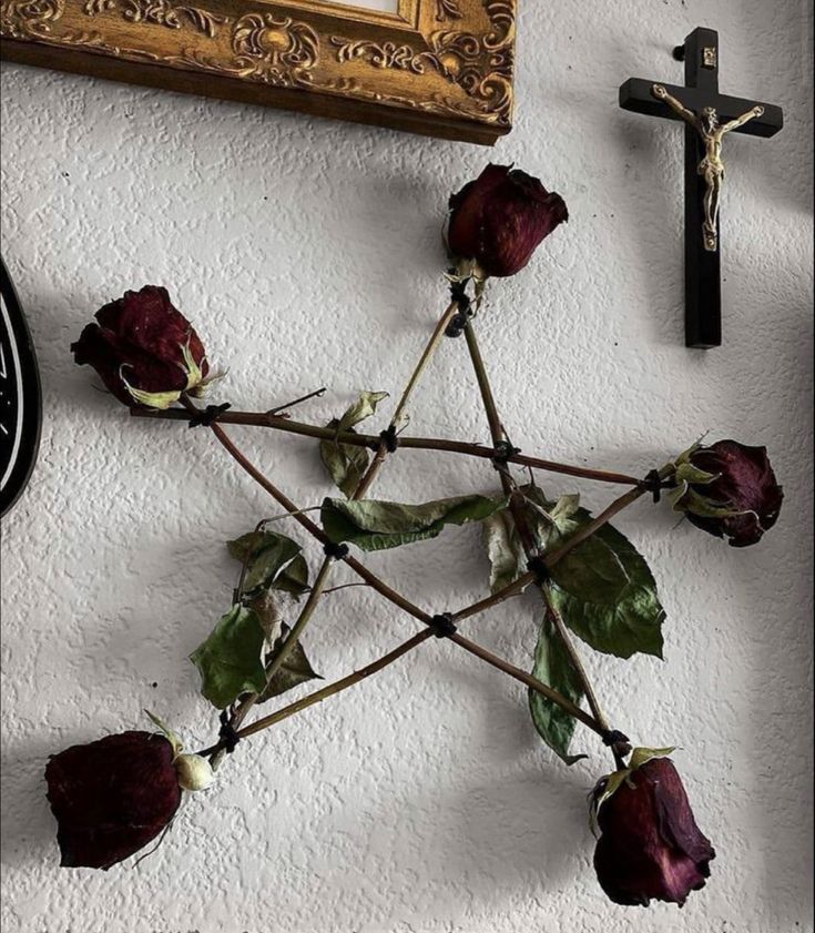 a cross and some flowers on a wall