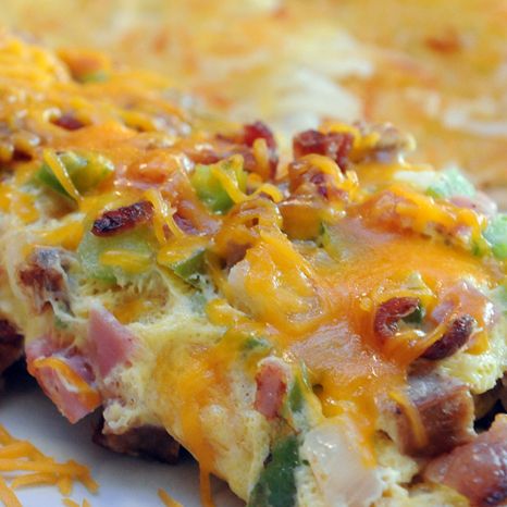 an omelet with bacon, cheese and other toppings