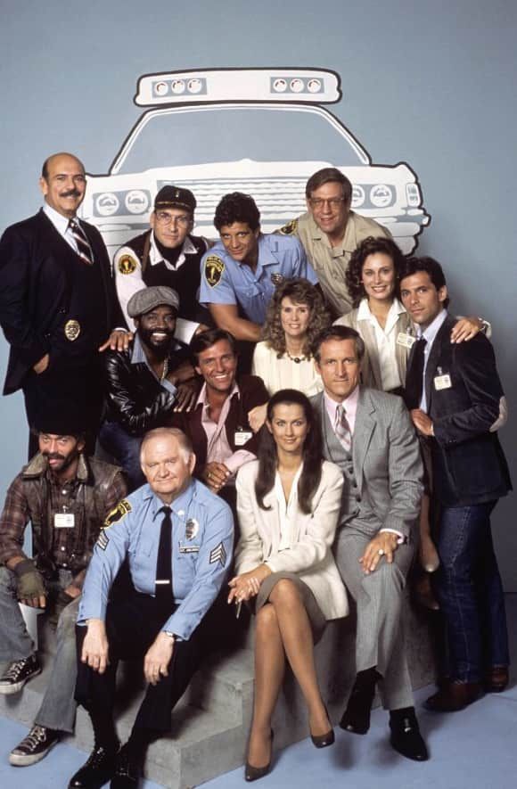 a group of people posing for a photo in front of a police car on a blue background