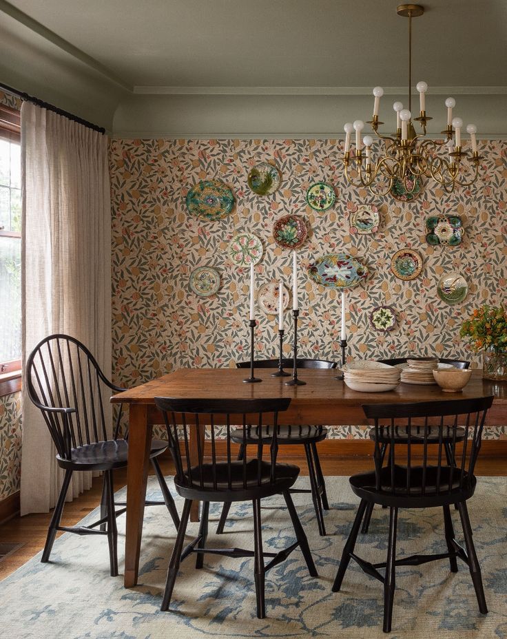 a dining room table with four chairs and a chandelier hanging from the ceiling