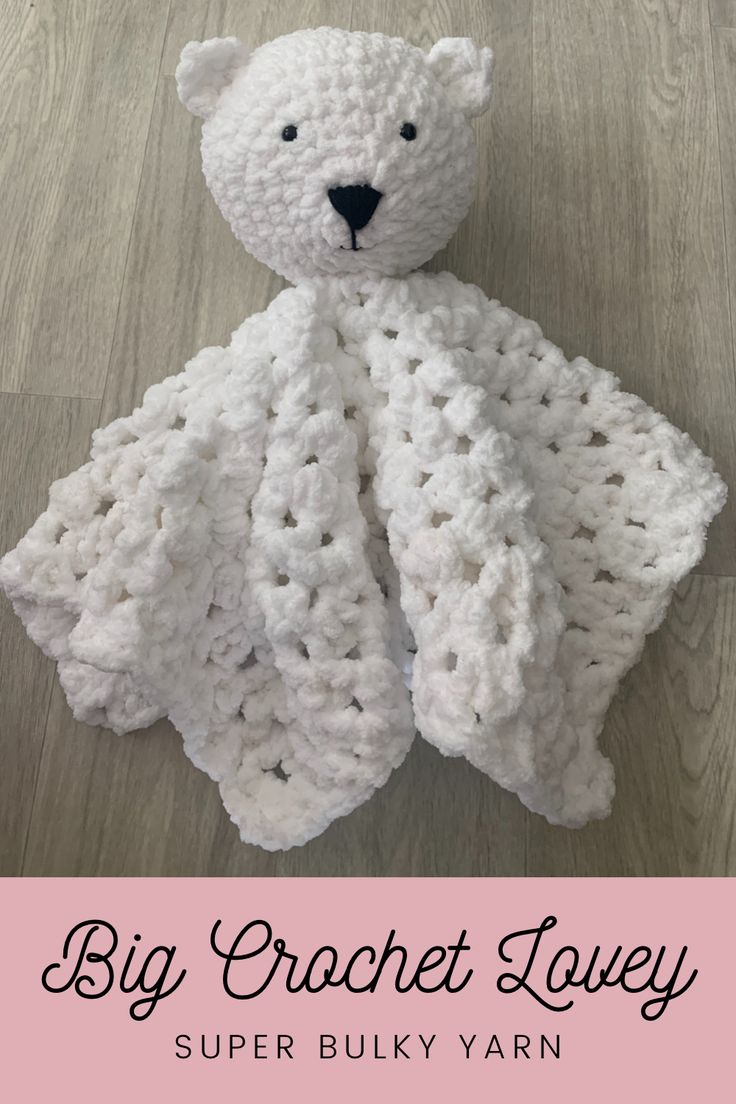 a white crocheted teddy bear sitting on top of a wooden floor with text overlay that reads, big crochet lovey super bulky yarn