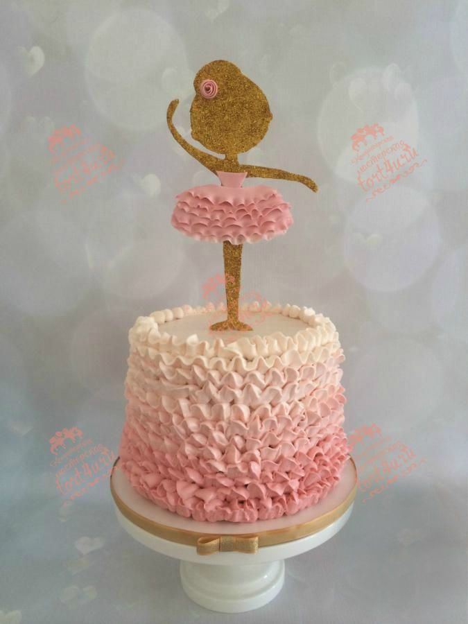 a cake decorated with pink and gold icing on top of a white pedestal in the shape of a ballerina