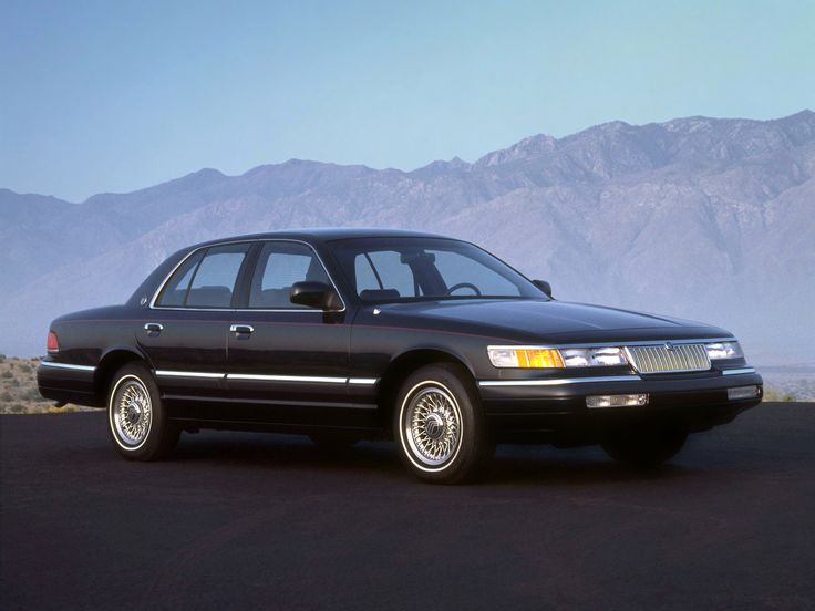 a black car parked in front of mountains