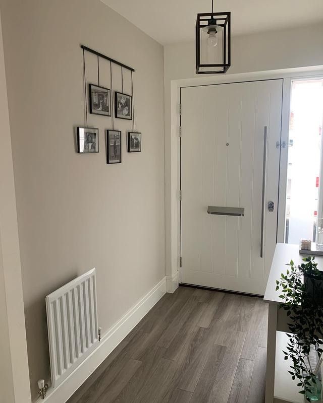 an empty hallway with pictures on the wall and a radiator next to it