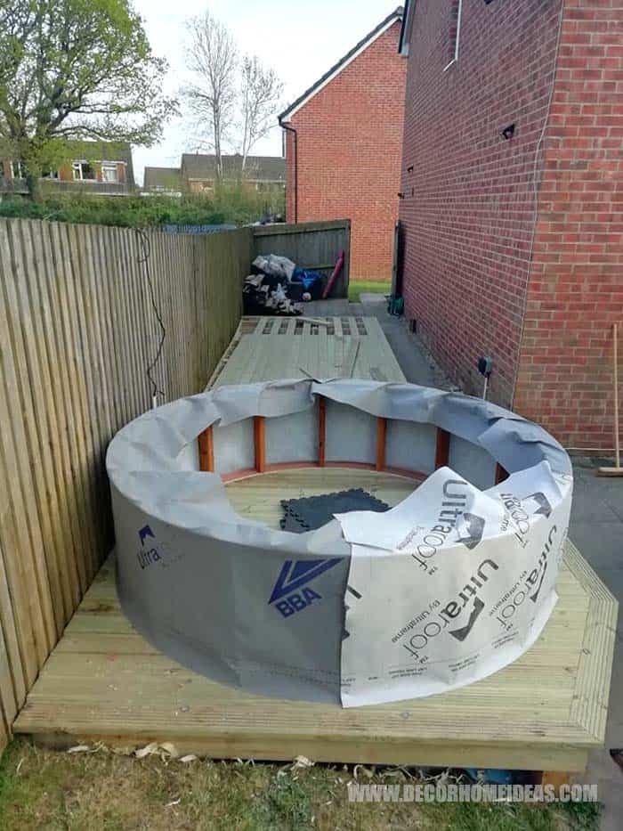 an outdoor swimming pool is being built in the back yard with some wood boards around it