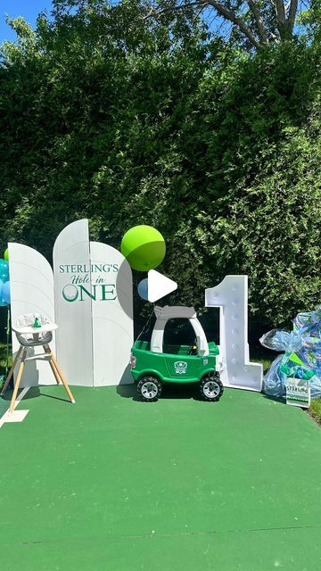 a green car parked in front of a sign