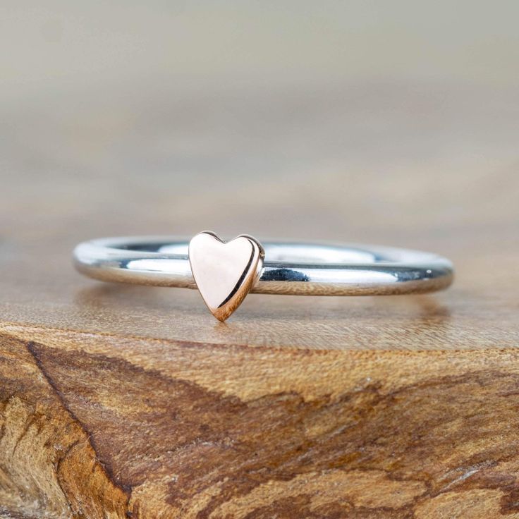 Featuring a gorgeous little solid 9ct rose gold or yellow gold heart perfectly polished upon a sterling silver band.  The heart rings stack perfectly together, or with other star, moon or gemstone rings.  Each piece is handmade in our small workshop in the village of Dounby on the Orkney Islands, a little island just off the top of Scotland.  You can choose to have the heart crafted in yellow gold or rose gold. Material - Made from solid sterling silver and solid 9ct yellow or rose gold. Hallmar Rose Gold Sterling Silver Heart Ring For Gift, Sterling Silver Rose Gold Heart Promise Ring, Dainty Sterling Silver Stackable Rings With Heart Charm, Rose Gold Sterling Silver Heart Promise Ring, Rose Gold Heart Cut Stackable Rings For Promise, Rose Gold Stackable Heart Ring For Valentine's Day, Heart Cut Rose Gold Stackable Promise Rings, Rose Gold Sterling Silver Midi Rings, Stackable Rose Gold Heart Ring For Valentine's Day