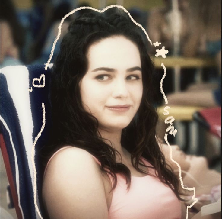 a woman sitting in a chair smiling for the camera