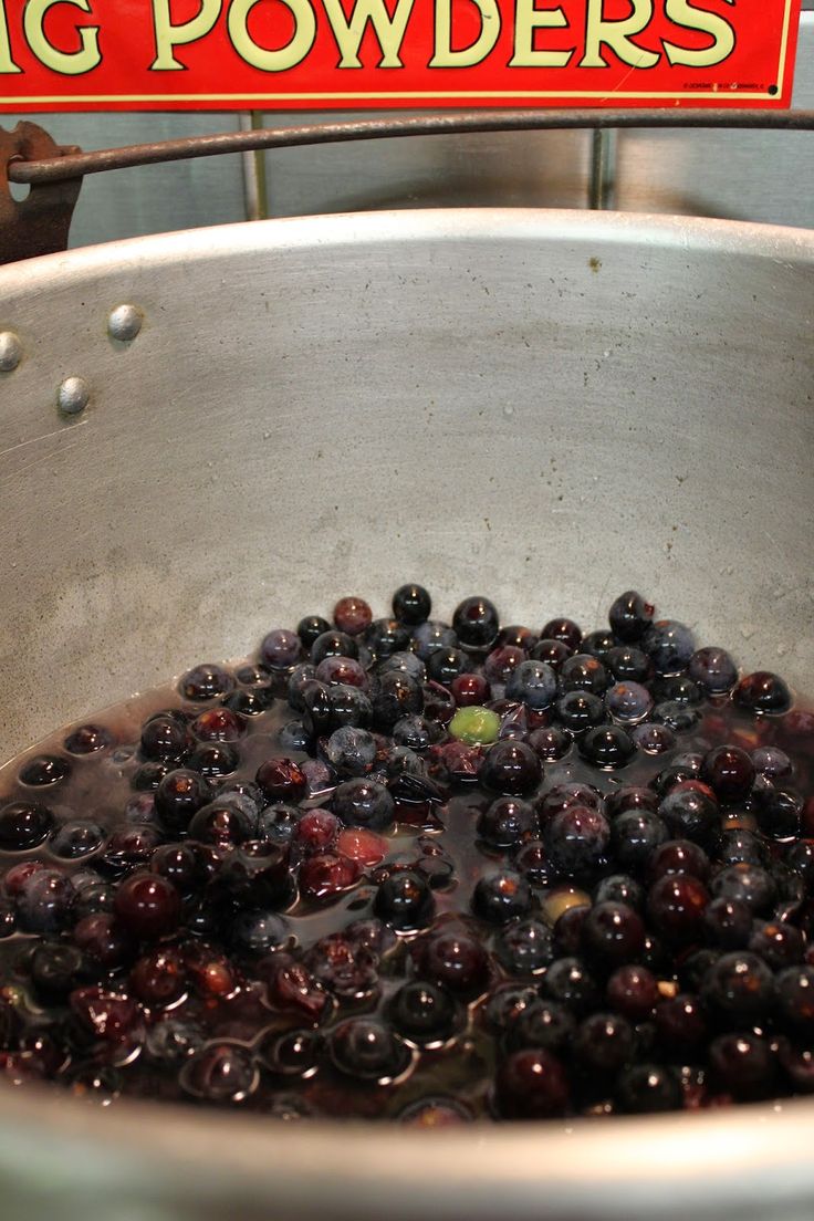 blueberries are being cooked in a pot with big powderers sign on the wall