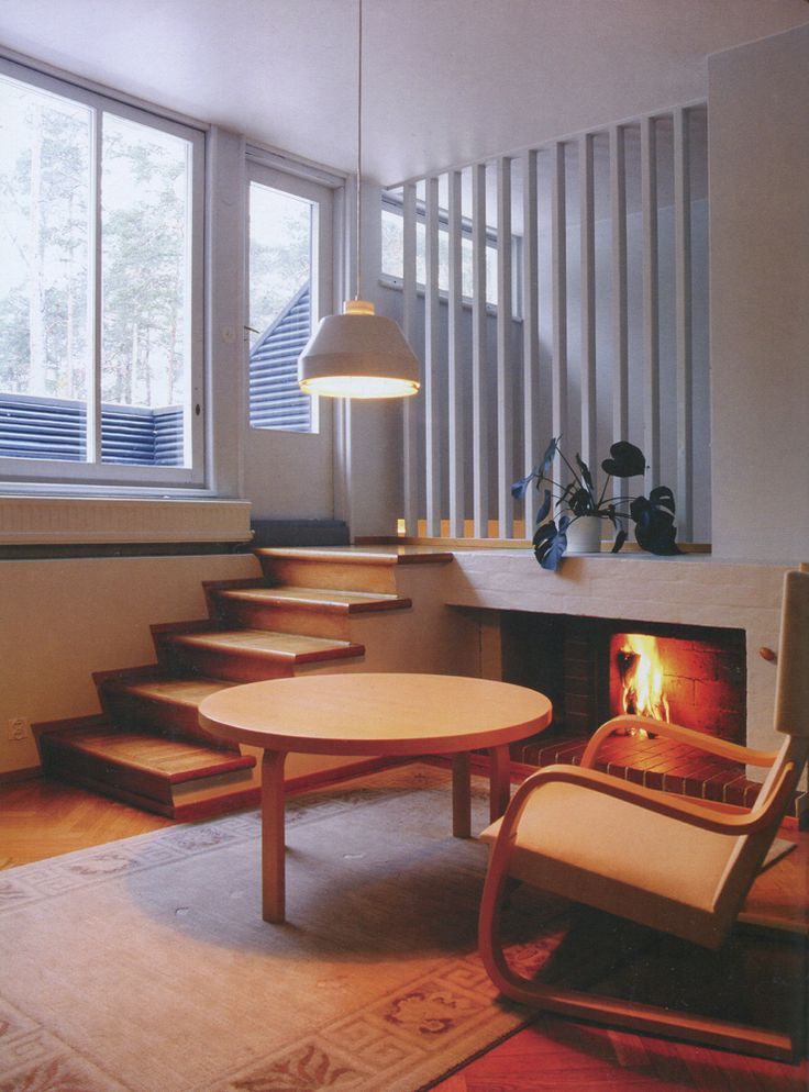 a living room filled with furniture and a fire place in front of a large window