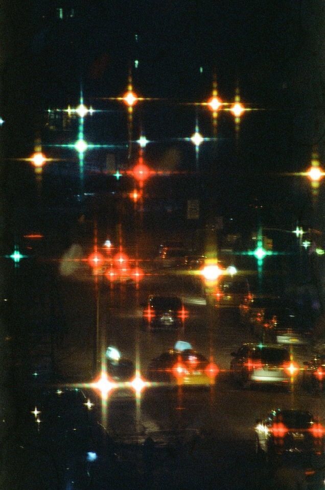 an image of traffic lights at night in the dark streetlights are brightly colored and blurry