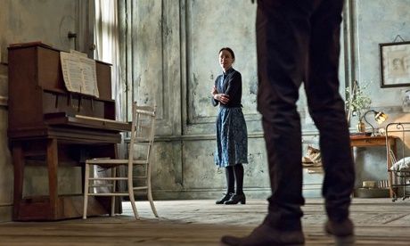 a woman standing next to a piano in a room