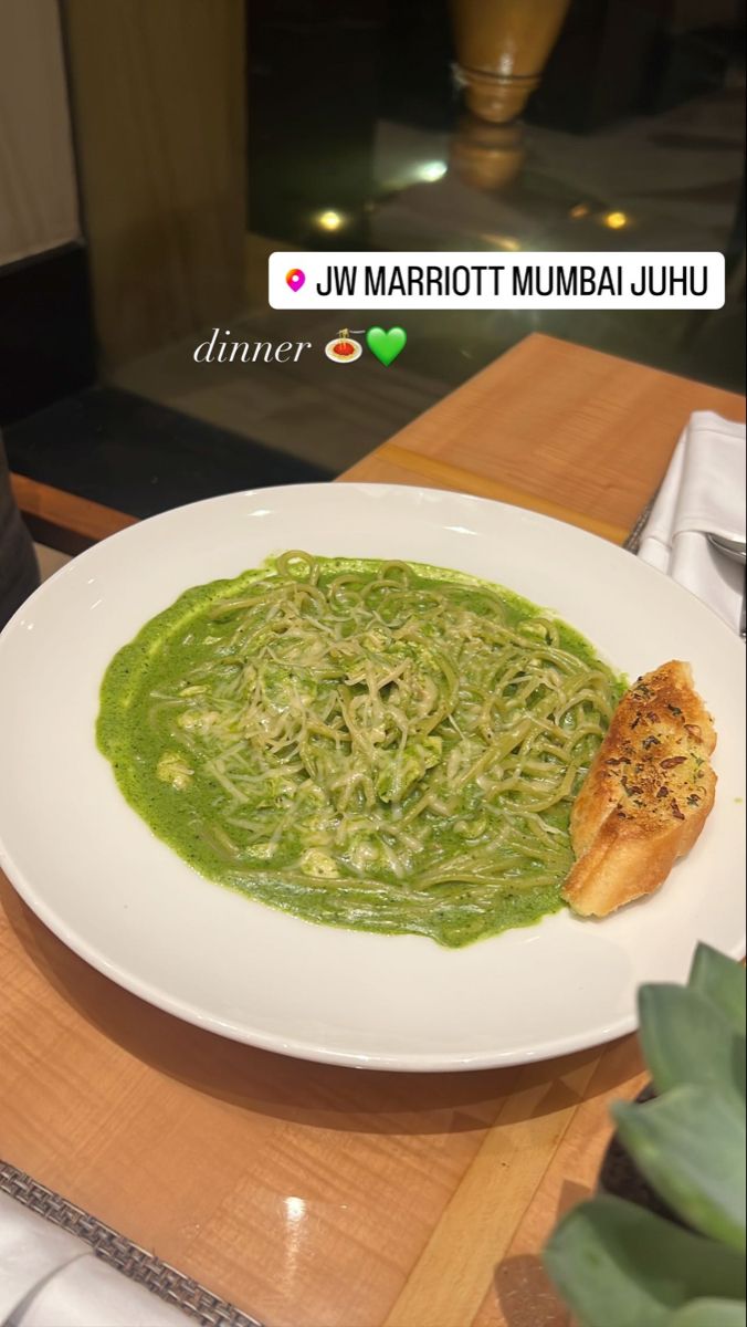 a white plate topped with green sauce on top of a wooden table