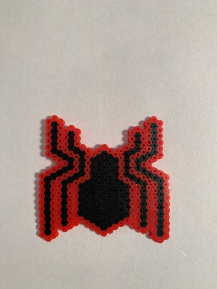 a red and black spiderman sticker sitting on top of a white surface