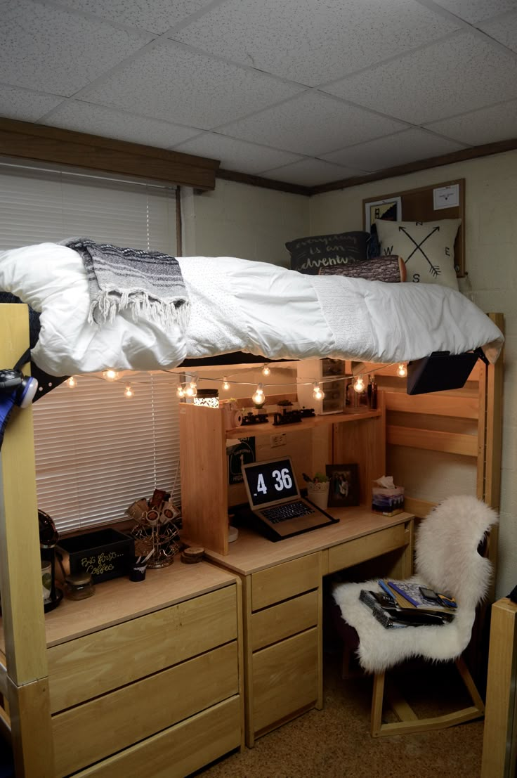 a bunk bed sitting in the middle of a bedroom next to a desk and chair