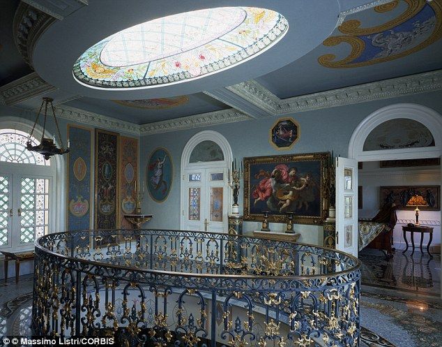 an ornate spiral staircase in the middle of a room with paintings on the walls and ceiling