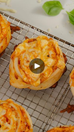 several mini pizzas on a cooling rack with cheese and meat toppings around them