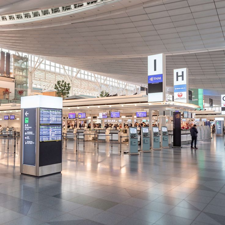 an airport terminal with people waiting for their luggage to arrive at the gates and check in counters