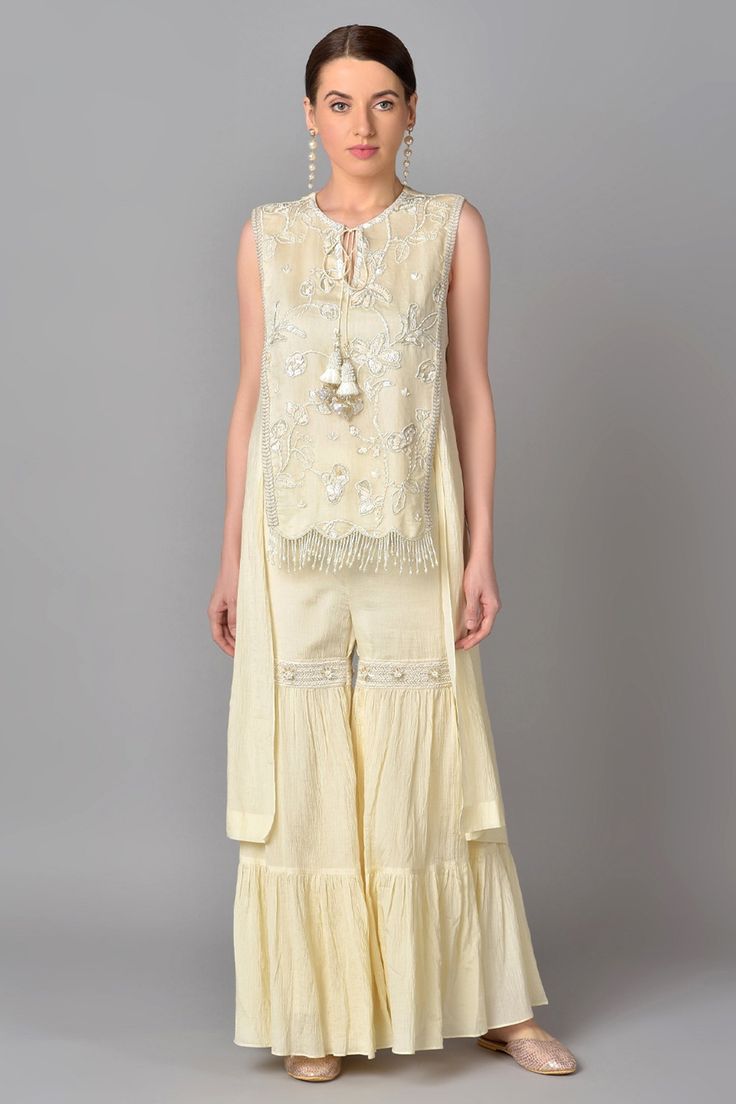 Ivory asymmetric kurta with floral embroidered motifs and front tassel tie-up. Paired with tiered and embroidered sharara.
Component: 2
Embroidered
Neckline: Round
Sleeve Length: Sleeveless
Fabric: Cotton Chiffon
Color: White
Front tassel tie-up - Aza Fashions Kurta And Sharara Set, Kurta And Sharara, Asymmetric Kurta, Embroidered Sharara, Embroidered Motifs, White Kurta, Sharara Set, Embroidered Neckline, Fashion App