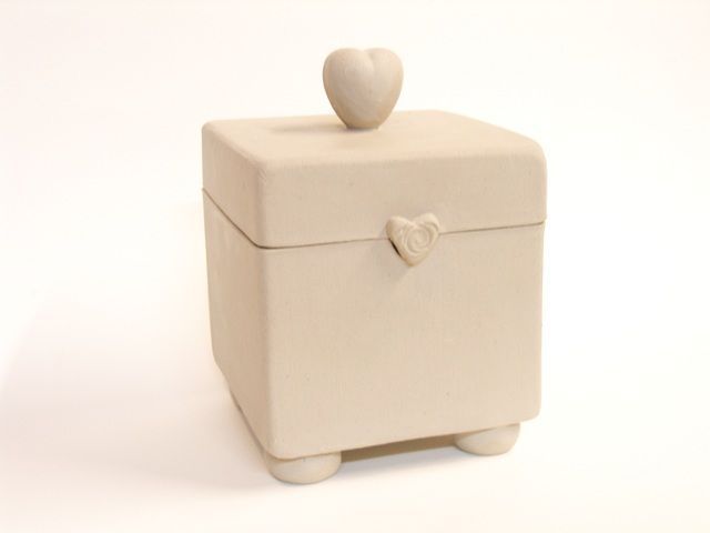 a small white box with a heart on the lid is shown in front of a white background