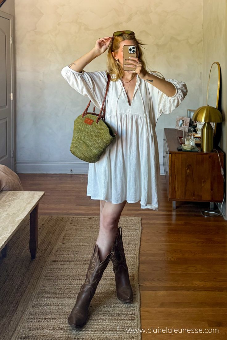 Found this super cute boho babydoll dress on Depop and styled it with my trustee brown leather cowboy boots and a raffia basket bag to go to a street festival. Loved the mesh of aesthetics. #springoutfitideas #festivaloutfitideas #coastalcowgirl #cowboybootsoutfit #raffiabag • how to style cowboy boots with a dress • how to style a babydoll dress • linen dress outfit ideas • Cowboy Boots Boho Outfit, Boho Dresses Casual, Styling Boots With Dresses, Cowboy Boot And Dress Outfit, Fall Outfit With Cowboy Boots, Brown Boots Outfit Summer, Cowboy Shoes Outfit, Cowboy Boots With Dress Outfit, How To Make An Outfit