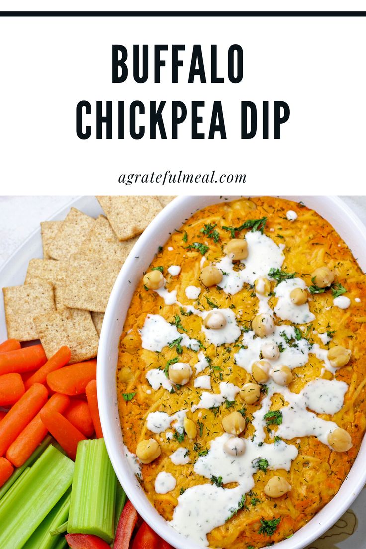 buffalo chicken dip in a white bowl surrounded by carrots, celery and crackers