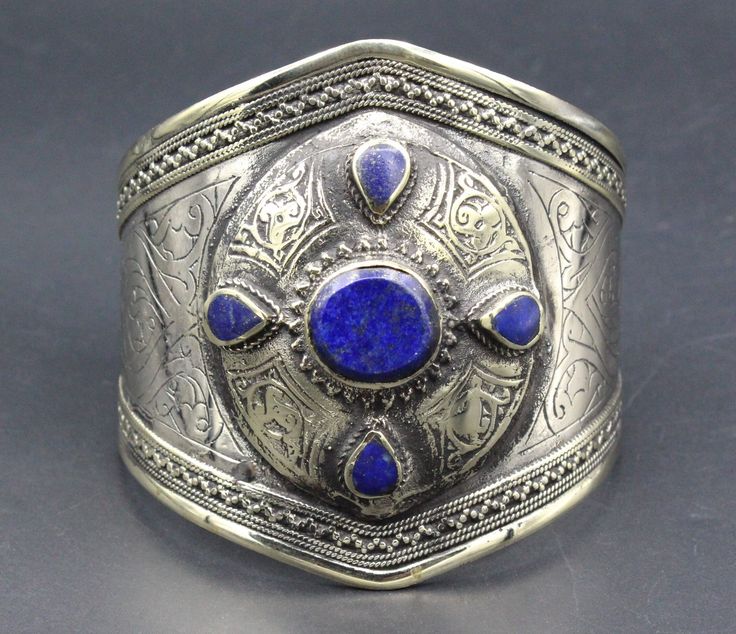 "Vintage Turkmen traditional alpaka bracelet. Its 100% hand crafted workmanship with beautiful Lapis Lazuli stone and lovely carved design. Please do not hesitate to contact if you have any questions. Weight : 68.1 grams, Opening of the mouth : 1.6\" ( 4 cm ) Inner circumference : 15 cm ( 5.9\" ) Width : 7cm ( 2.8\" ) Please know what you are bidding on. The metal of Most Kuchi, Afghan and Turkoman items are called with different names, Some called Alpaca silver, German Silver and Tibetan Silver Artisan Cuff Bracelet As Festival Gift, Artisan Bangle Cuff Bracelet For Festivals, Handmade Bohemian Bracelets For Festival, Bohemian Cuff Bracelet For Festivals Gift, Spiritual Festival Bangle Cuff Bracelet, Adjustable Spiritual Cuff Bracelet For Festivals, Traditional Bangle Bracelet For Festivals, Handmade Spiritual Cuff Bracelet For Festivals, Traditional Blue Adjustable Cuff Bracelet