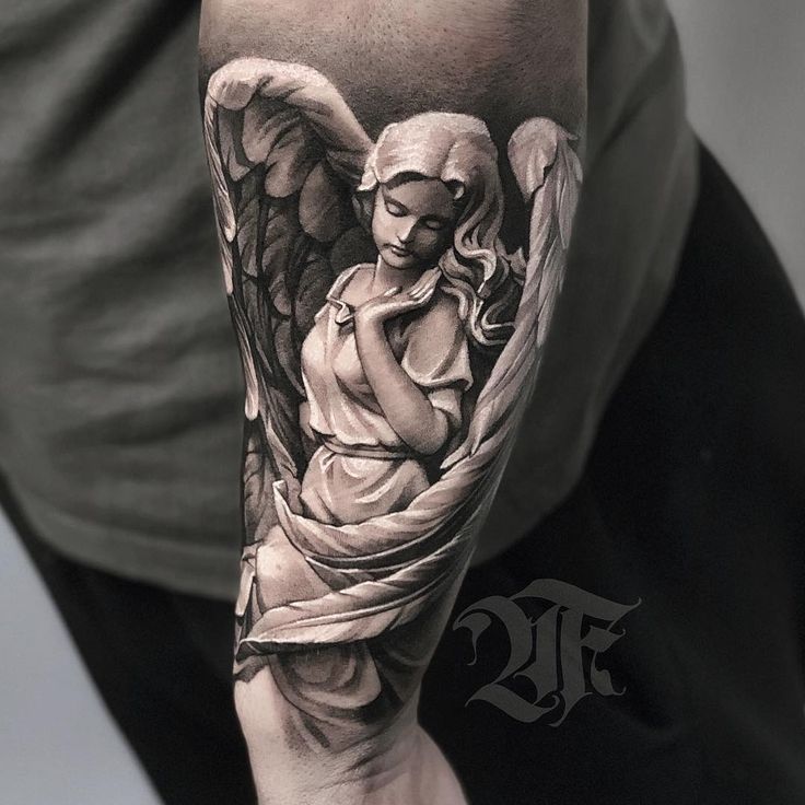 a man with a tattoo on his arm holding an angel