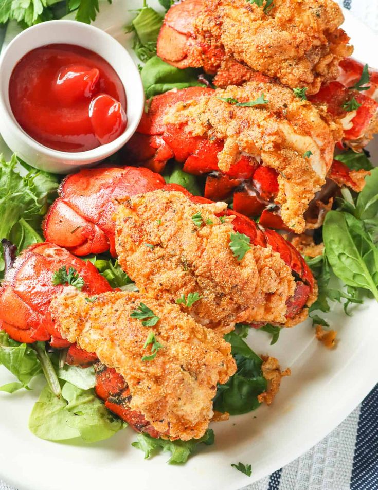 crab cakes with lettuce and ketchup on a white plate