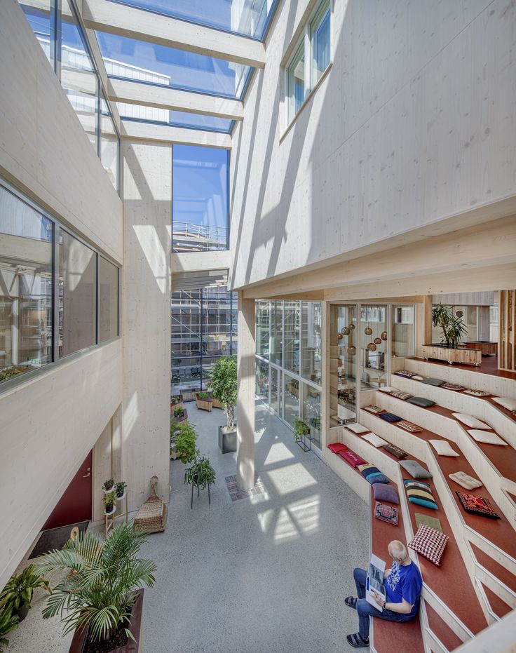 the inside of a large building with lots of windows and plants on the outside wall