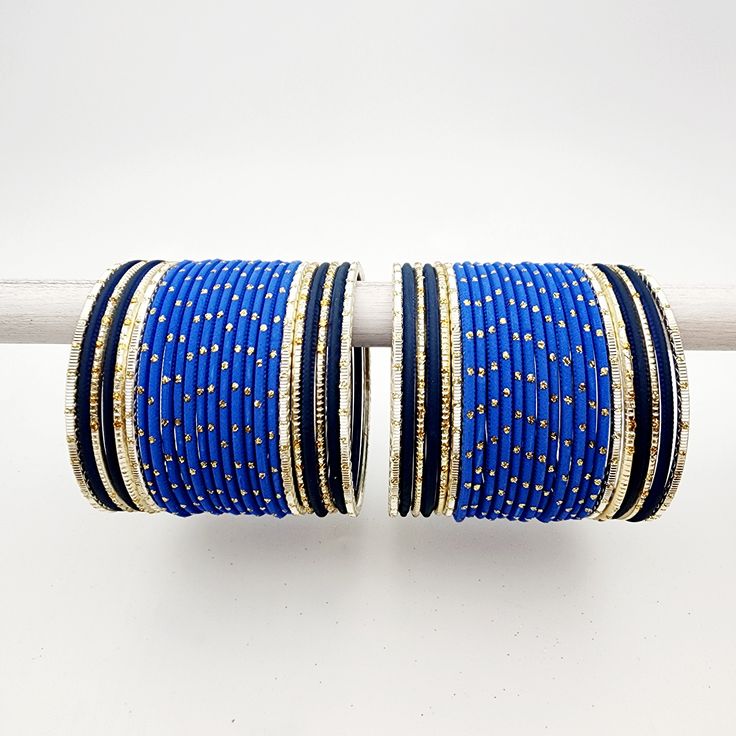 This elegant bangle set is designed in a stunning shades of blue with intricate gold accents. The set includes bangles for both arms, offering a harmonious blend of vibrant color and exquisite detailing. Luxury Blue Bangle For Anniversary, Cheap Blue Bohemian Bangle, Cheap Blue Bangle As A Gift, Luxury Blue Bangle For Wedding, Cheap Handmade Blue Bangle, Luxury Traditional Blue Bangle, Bangle Set, Gold Accents, Shades Of Blue