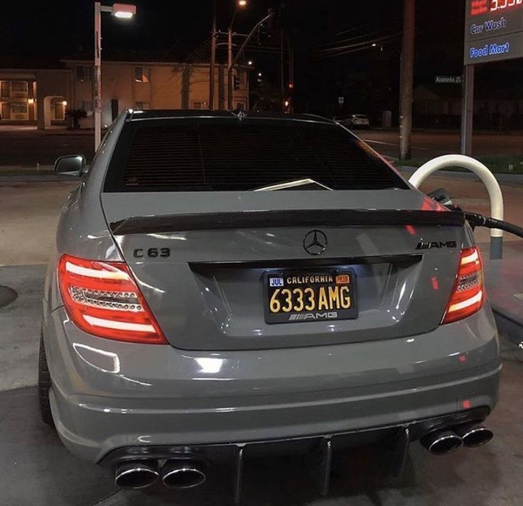 the back end of a mercedes benz cls parked in a gas station at night