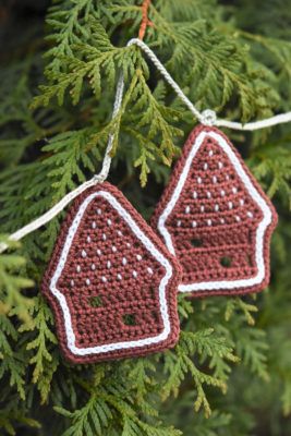 two crocheted christmas ornaments hanging from a tree