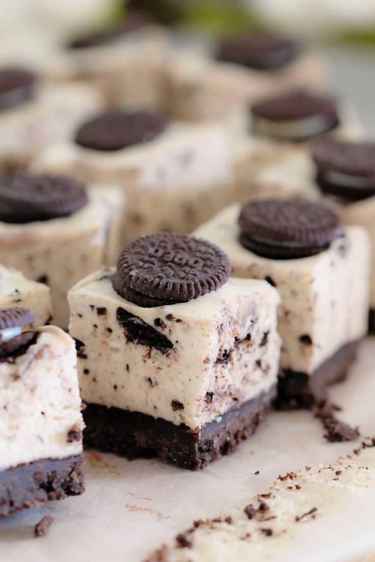 oreo cookies and cream cheesecake desserts are arranged on a cutting board, ready to be eaten