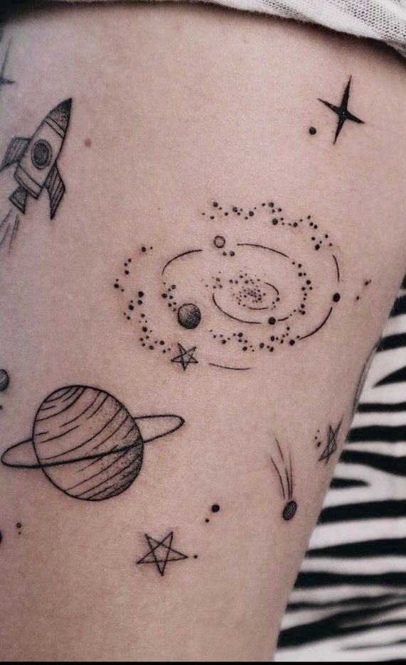 a woman's thigh with an image of planets and stars on it