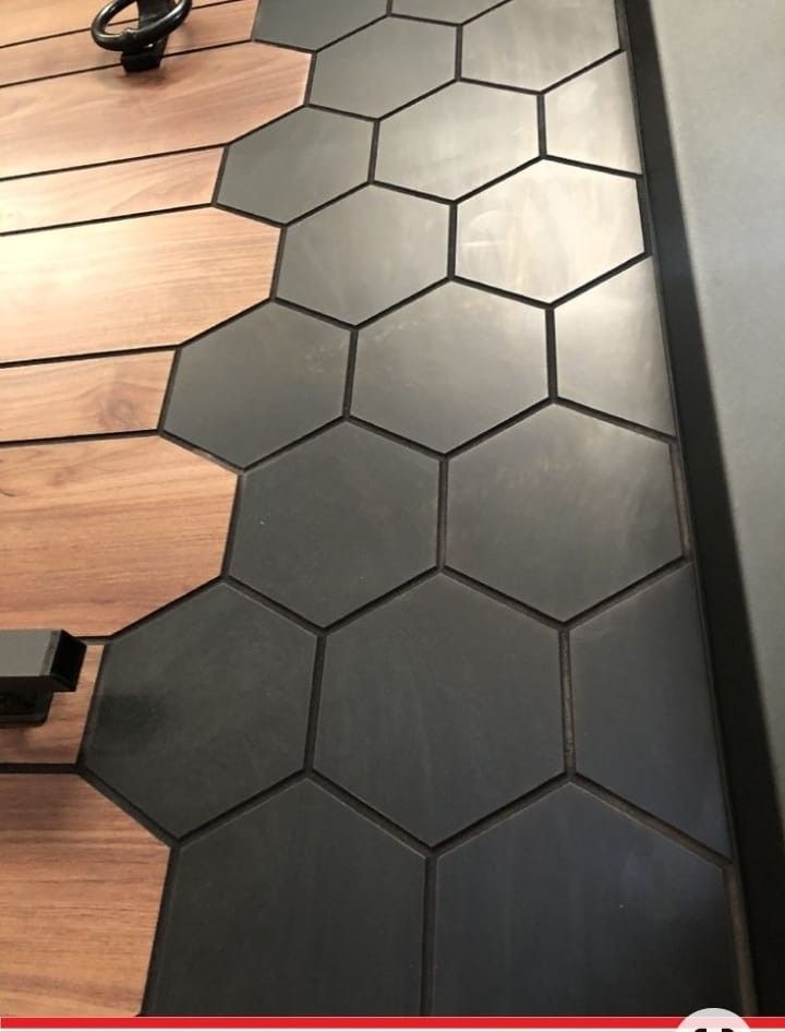 the floor is made up of black hexagonal tiles and wood planks, along with a phone charger