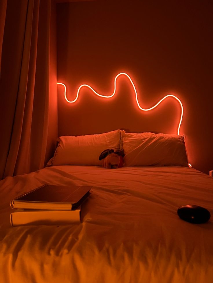 View of bed in bedroom with neon led rope light on orange Rope Lights Bedroom Ideas, Bedroom Rope Lighting Ideas, Led Rope Lights Bedroom Ideas, Squiggly Led Light On Wall, Rope Light Bedroom, Led Rope Lights Bedroom, Led Rope Lighting Ideas, Rope Light Design, Rope Lights Bedroom