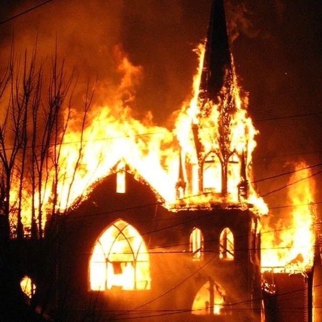 a church on fire burning in the night