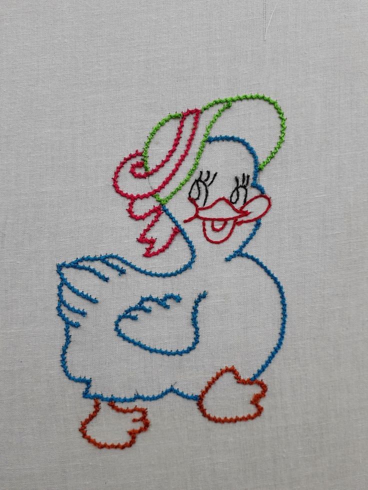 a close up of a embroidery on a piece of cloth with an image of a duck