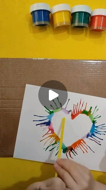 someone is making a heart shaped card with crayons