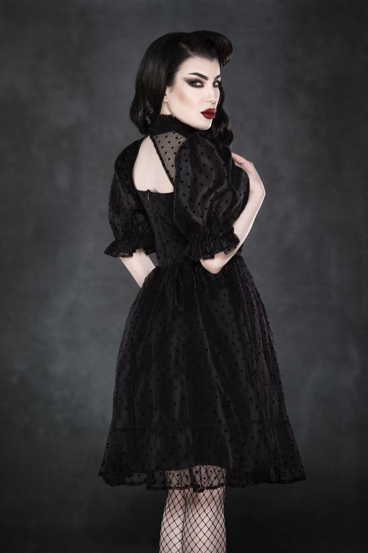 Inspired by the arches of a Gothic cathedral, this romantic mini-dress features a dramatic triangle neckline and delicate silver cross charm hanging from the collar. Made from retro polka-dot chiffon in layers with oversized puffed ¾ sleeves and full skirt with sheer coverage to the knee. Model Measurements: Bust: 34.5 inches Waist: 24.5-25 inches Hips: 37 inches Model is wearing size XS. Fabric has little stretch. Cold Water Wash Delicate & Hang to Dry. Fitted Swiss Dot Evening Dress, Evening Swiss Dot Fitted Dress, Party Dresses With Swiss Dot And Short Sleeves, Swiss Dot Short Sleeve Party Dress, Short Sleeve Swiss Dot Party Dresses, Cathedral Dress, Romper Men, June Dress, Gothic Cathedral