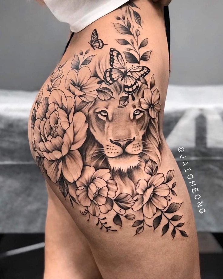 a woman's thigh with flowers and a lion on it