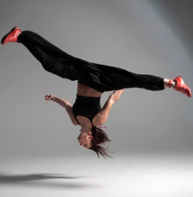 a woman is doing a handstand in the air with her legs spread out